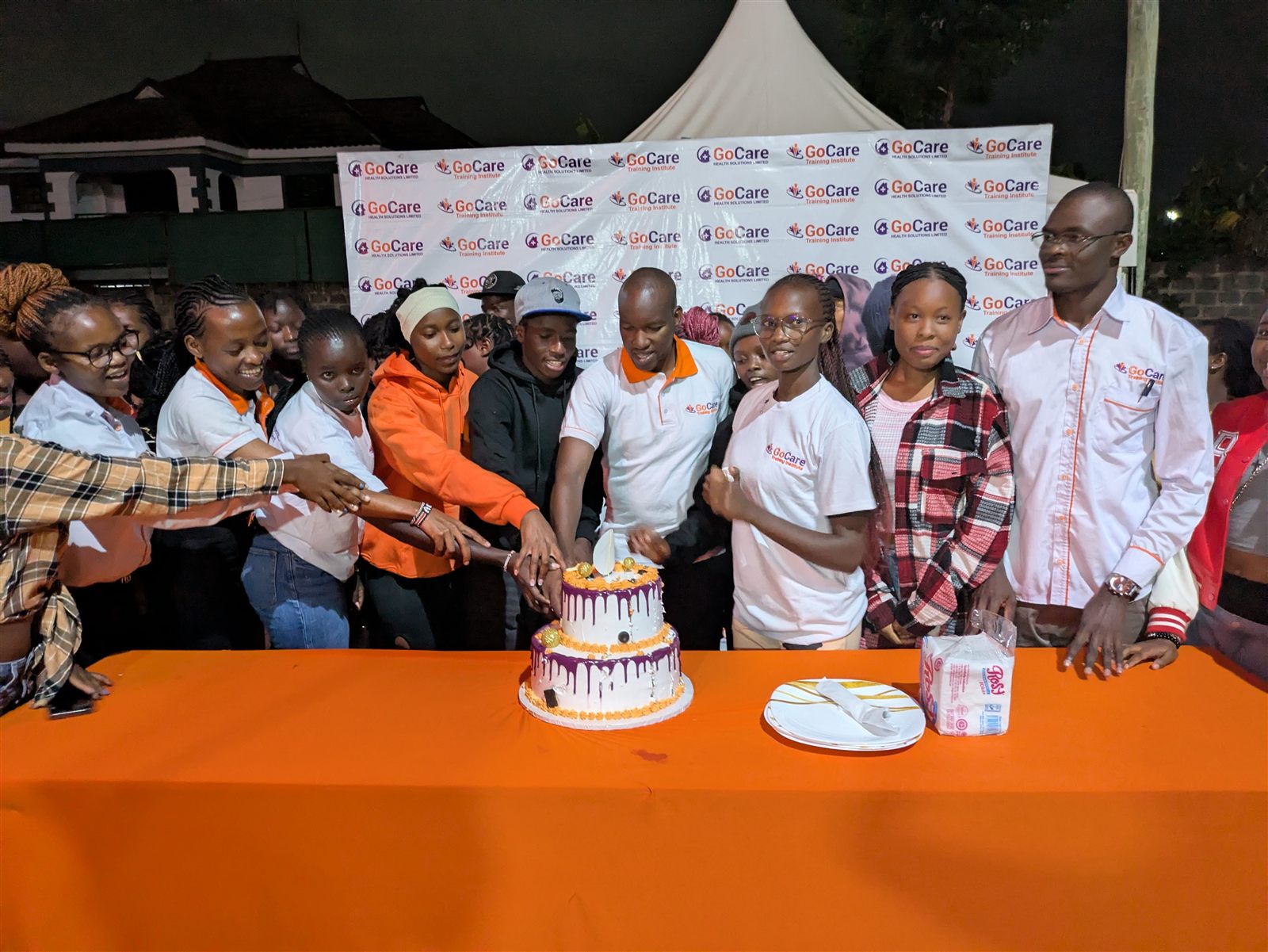 GoCare alumni and students celebrating together at a community event